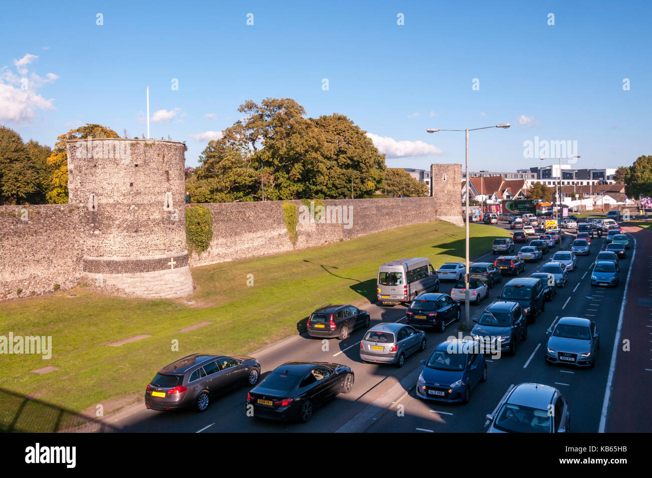 Hohes Verkehrsaufkommen in Canterbury queuing vorbei an alten Stadtmauern Stockfoto