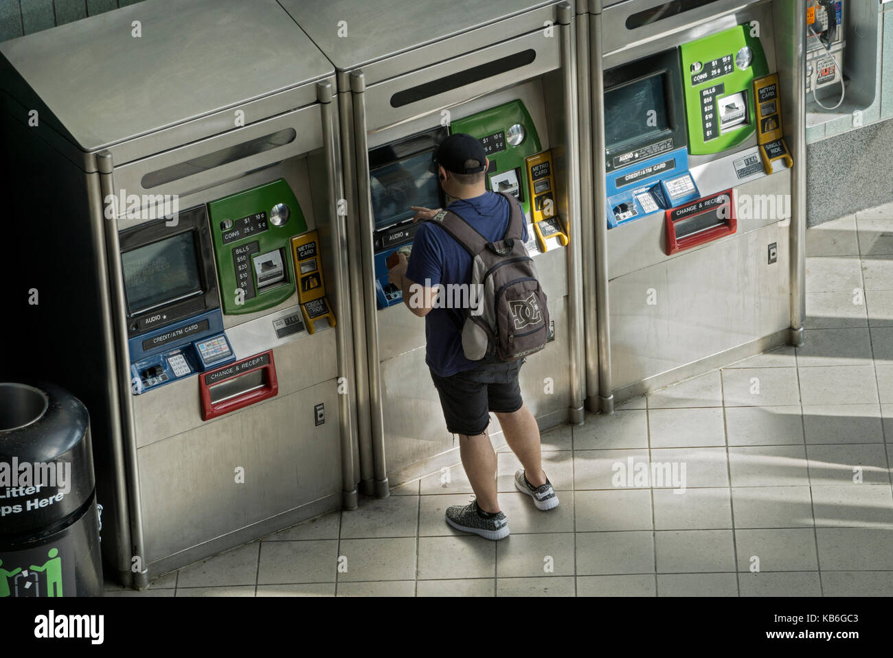 Ein junger Mann mit einem Rucksack Einkauf oder Nachfüllen von seinem metrocard an der 74th Street Broadway Station auf der 7. In Jackson Heights, Queens, NYC Stockfoto