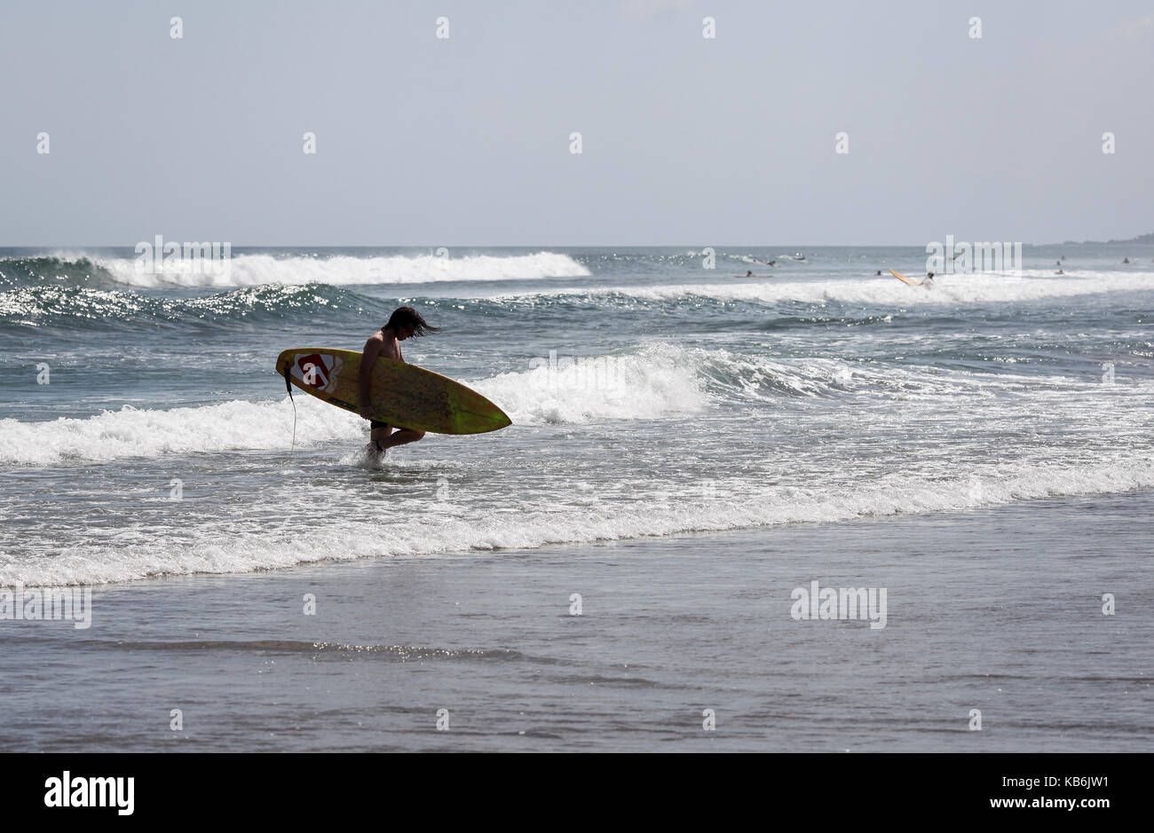 Die Surfer mit dem lange Platte entlang dem Strand von Legian, Bali, Indonesien, Stockfoto