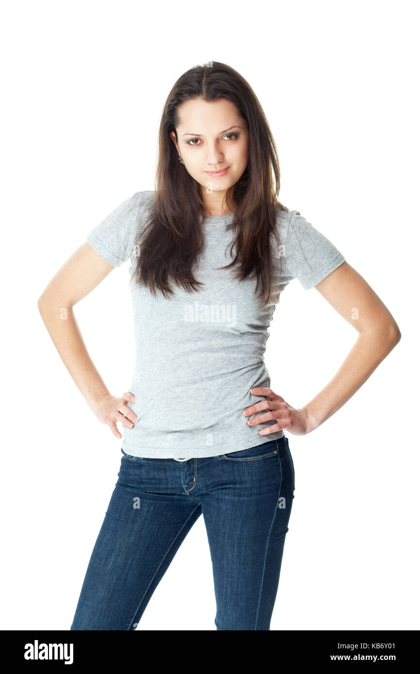 Porträt der hübsche junge brünette Frau trägt blaue Jeans und T-Shirt grau auf weißem Hintergrund Stockfoto
