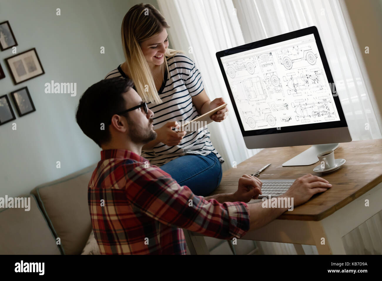 Junge attraktive Designer zusammen arbeiten von zu Hause aus Stockfoto