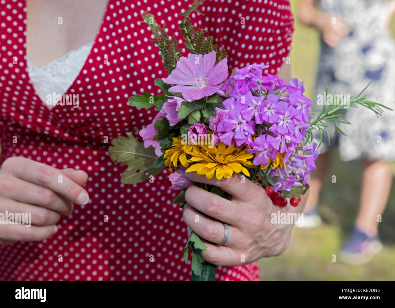 Finnland, Minnesota - Die Braut trägt ein Bouquet von Wildblumen während ihrer Hochzeit im Freien. Stockfoto