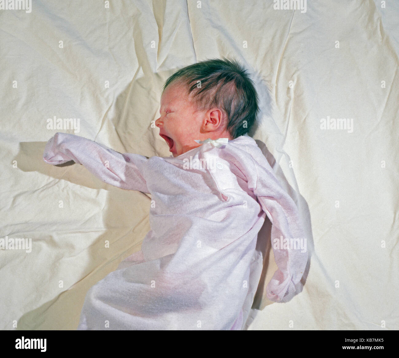 Ein 1 Wochen altes Baby girl in a body, Gähnen, während ein Nickerchen. Stockfoto