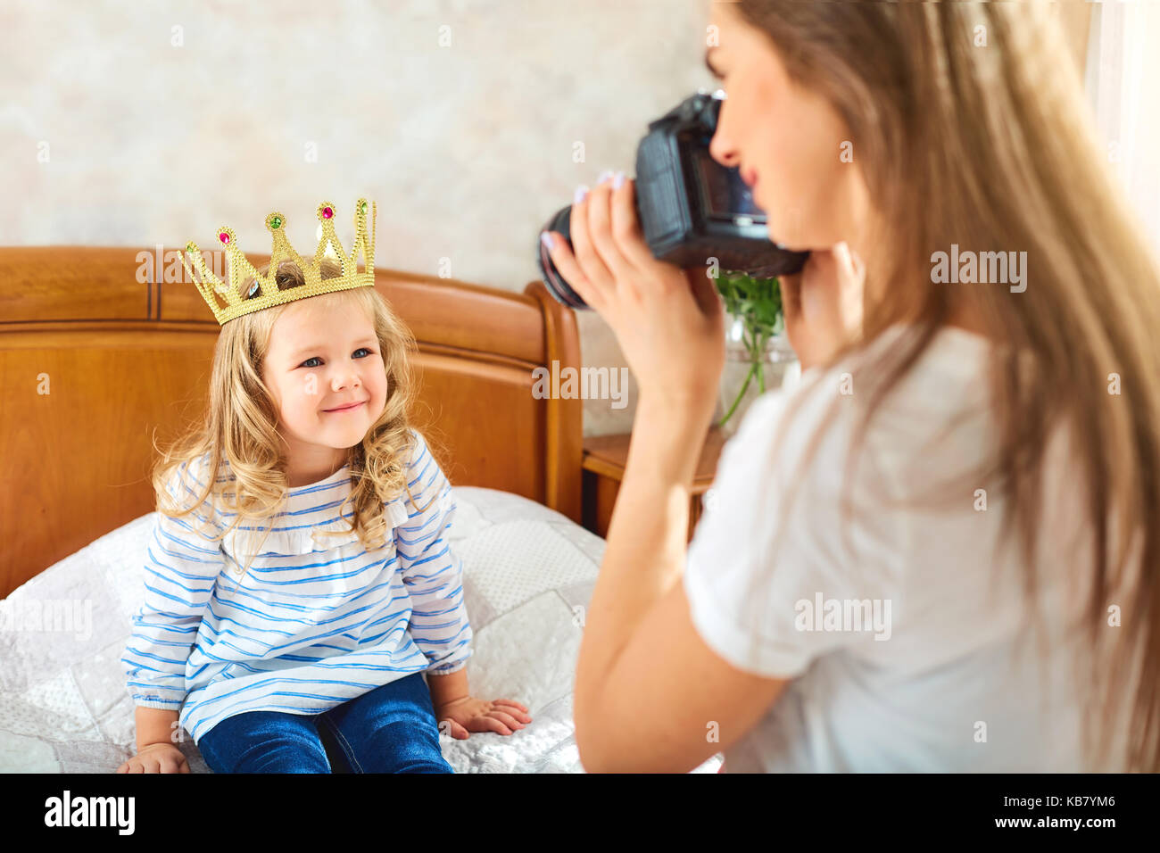 Mama nimmt Bilder Ihres Kindes in einen Raum durch das Fenster. Stockfoto
