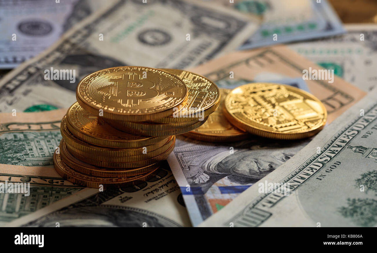 Golden bitcoins auf Dollar Banknoten Hintergrund gestapelt Stockfoto