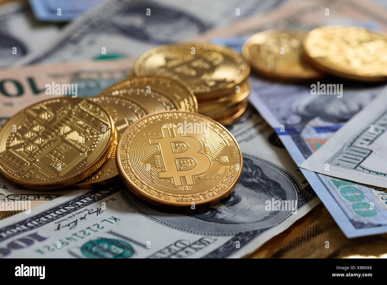 Golden bitcoins auf Dollar Banknoten Hintergrund gestapelt Stockfoto