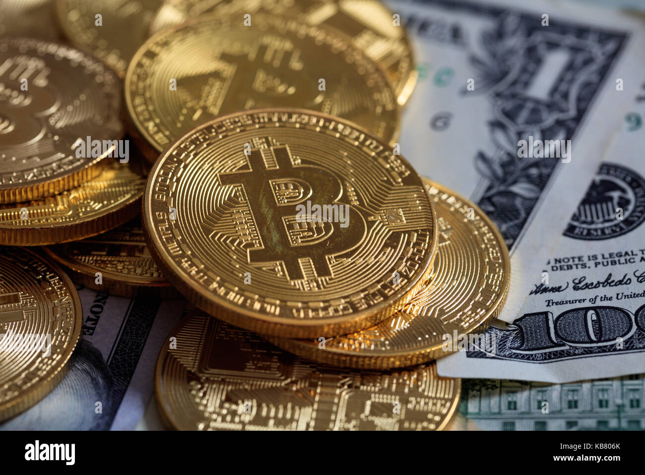 Golden bitcoins auf Dollar Banknoten Hintergrund gestapelt Stockfoto