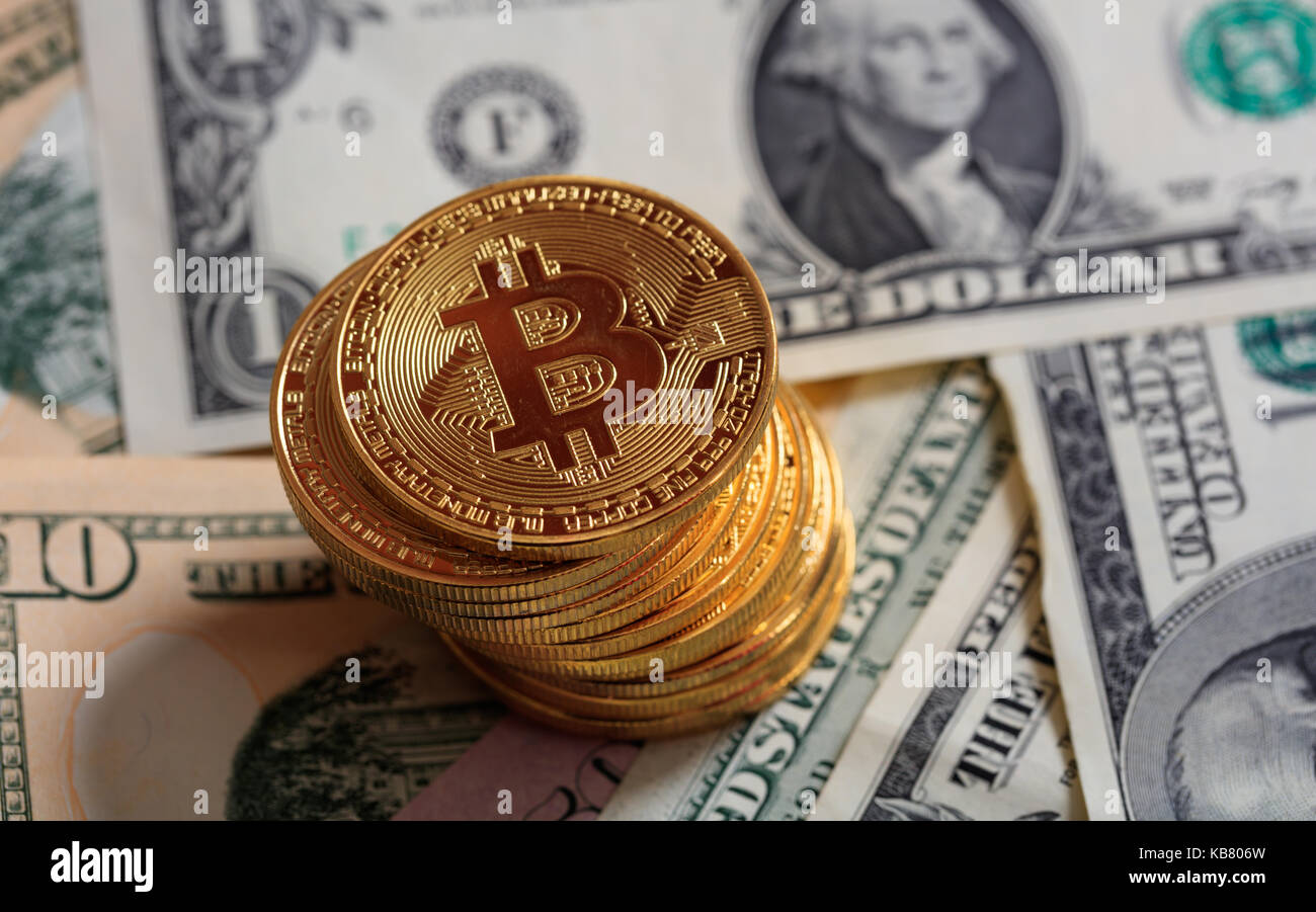 Golden bitcoins auf Dollar Banknoten Hintergrund gestapelt Stockfoto