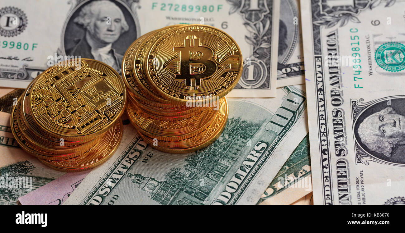 Golden bitcoins auf Dollar Banknoten Hintergrund gestapelt Stockfoto