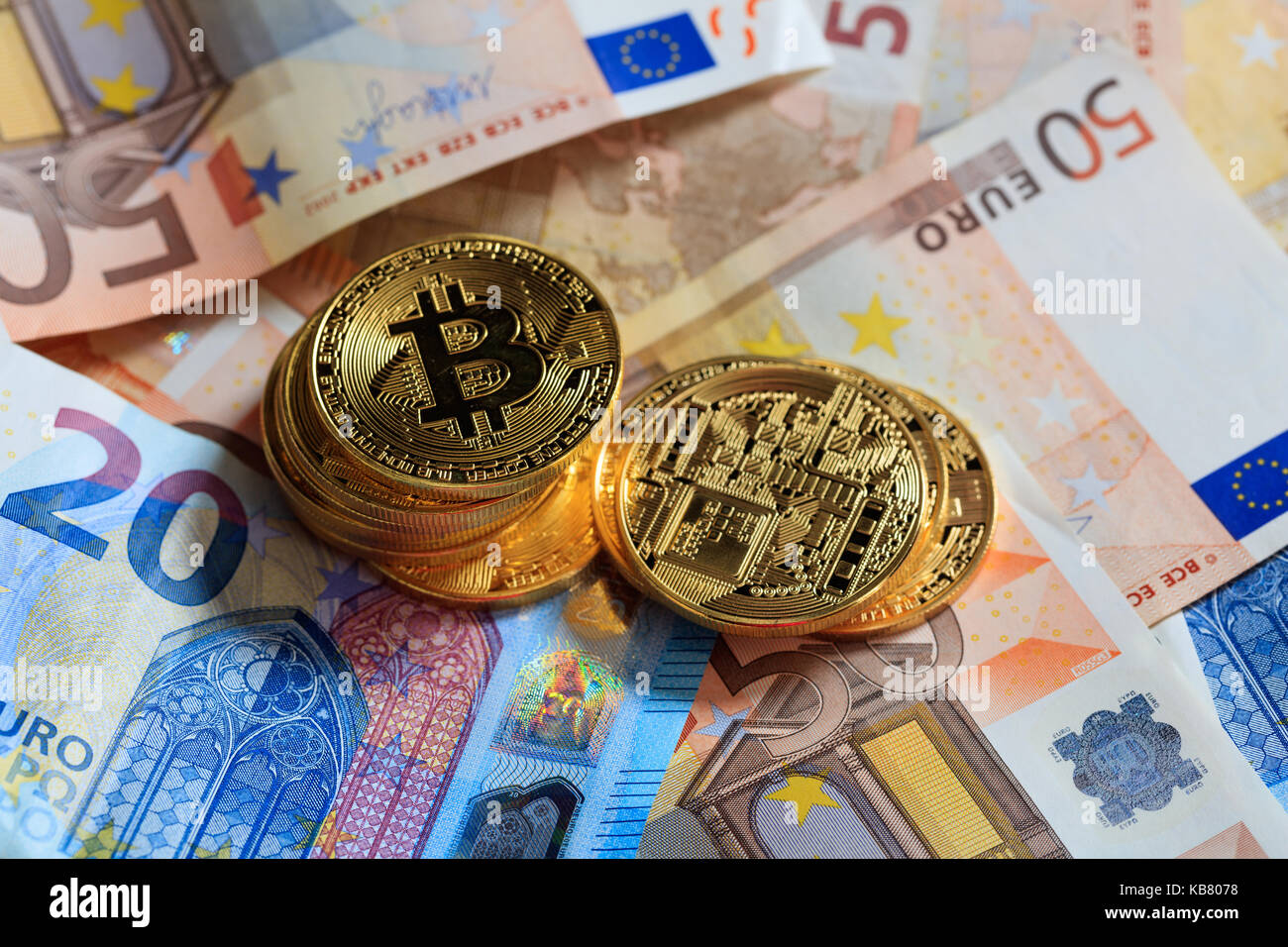 Golden bitcoins auf Euro-banknoten Hintergrund gestapelt Stockfoto