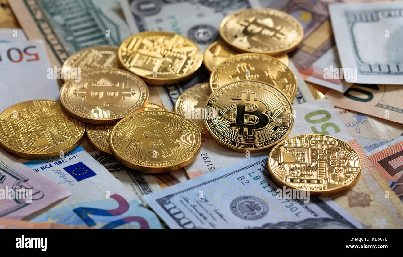 Golden bitcoins auf Dollar und Euro Banknoten Hintergrund gestapelt Stockfoto