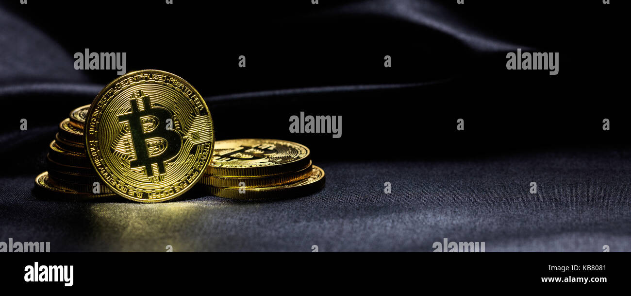 Golden bitcoins auf einem schwarzen Textur Hintergrund gestapelt Stockfoto