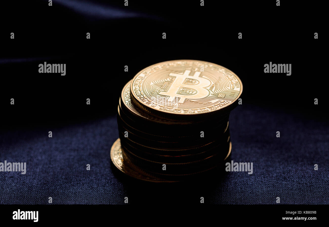 Golden bitcoins auf einem schwarzen Textur Hintergrund gestapelt Stockfoto