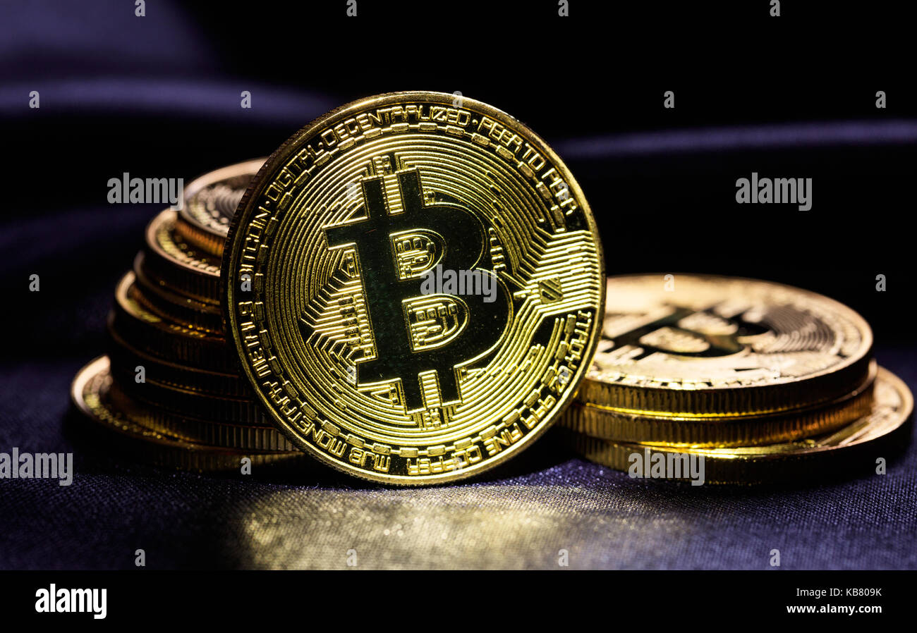 Golden glänzenden Bitcoins auf schwarzem Hintergrund gestapelt Stockfoto