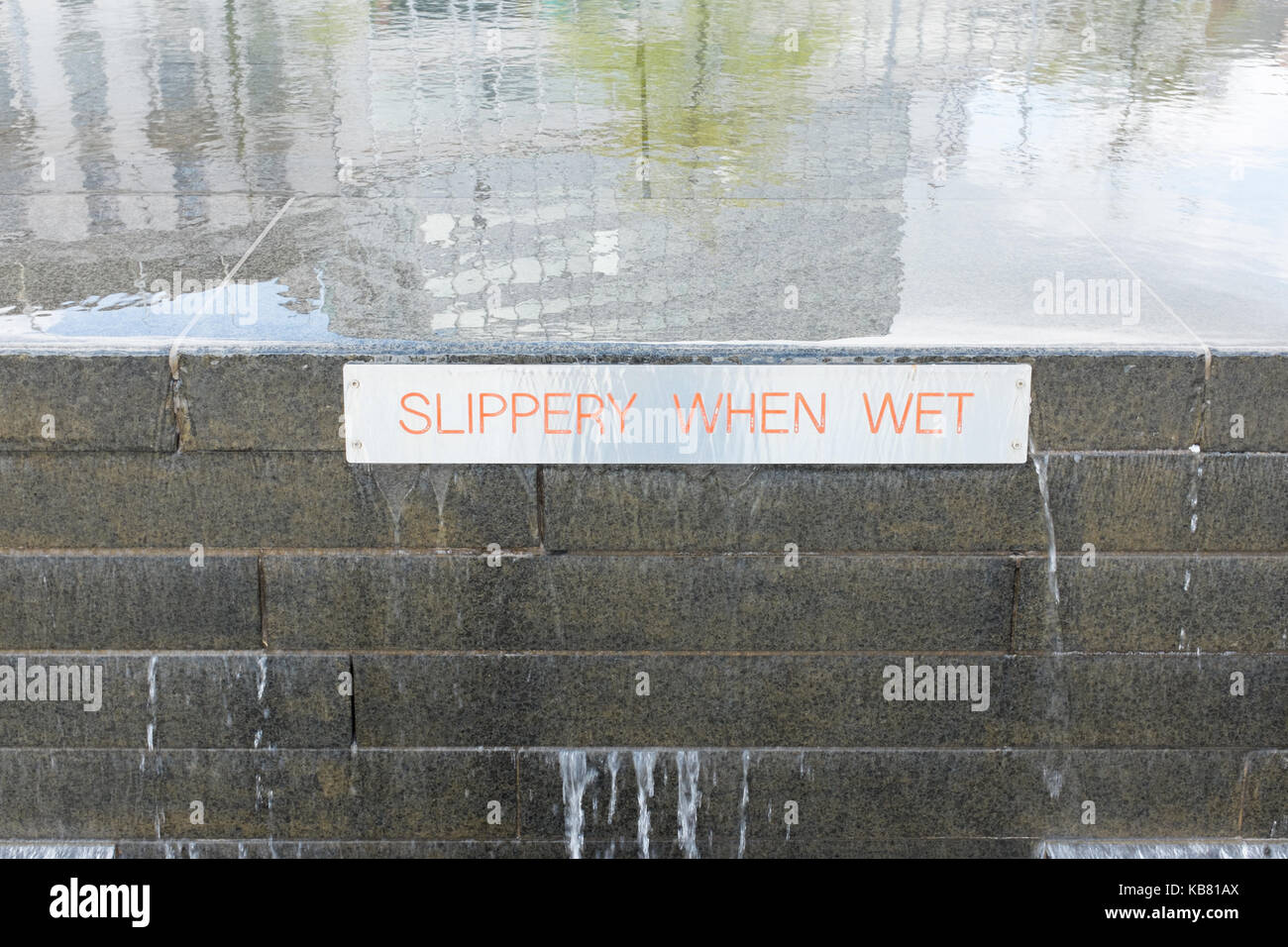 Schild an einem Wasserspiel in Old Market Square, Nottingham, rutschig, wenn er nass Stockfoto