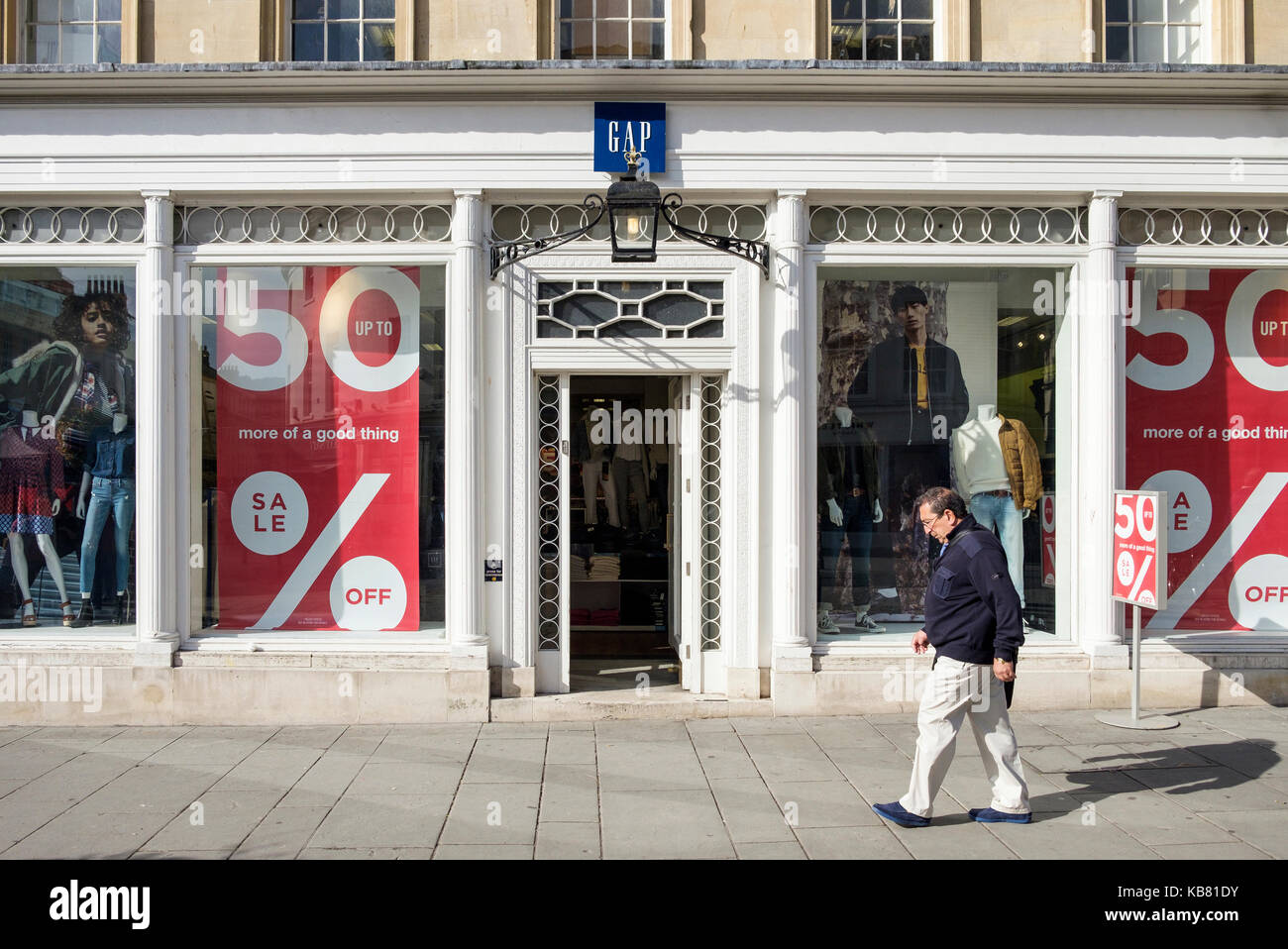 Ein Mann wird dargestellt, wie er letzten Spaziergänge Vergangenheit eine Lücke mode bekleidung shop Front auf der High Street in Bath, Somerset, England, Großbritannien Stockfoto