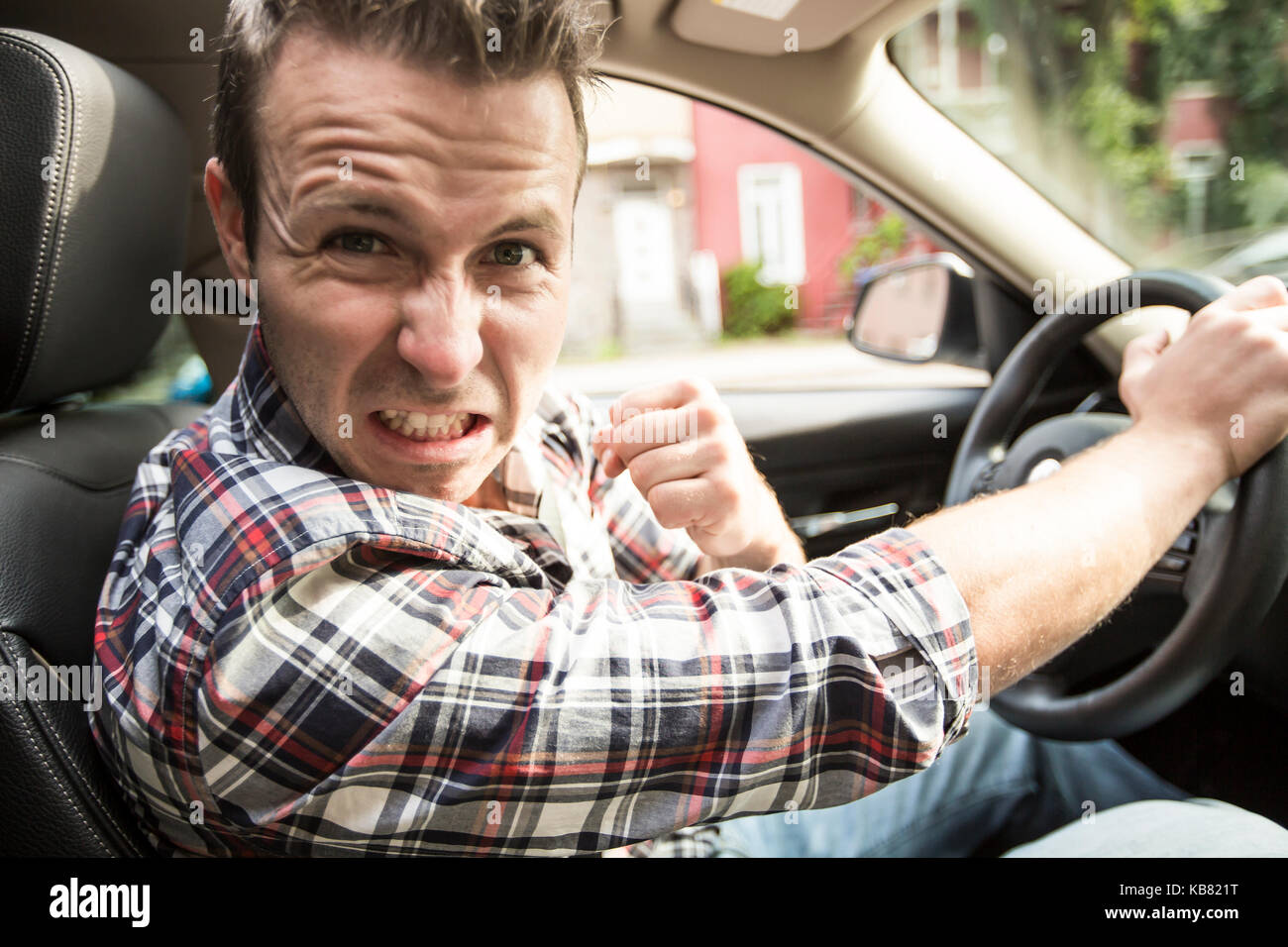 Junger Mann, der ein Auto fährt irritiert. Irritierte Fahrer Stockfoto