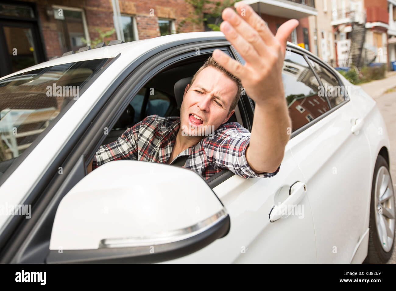Junger Mann, der ein Auto fährt irritiert. Irritierte Fahrer Stockfoto