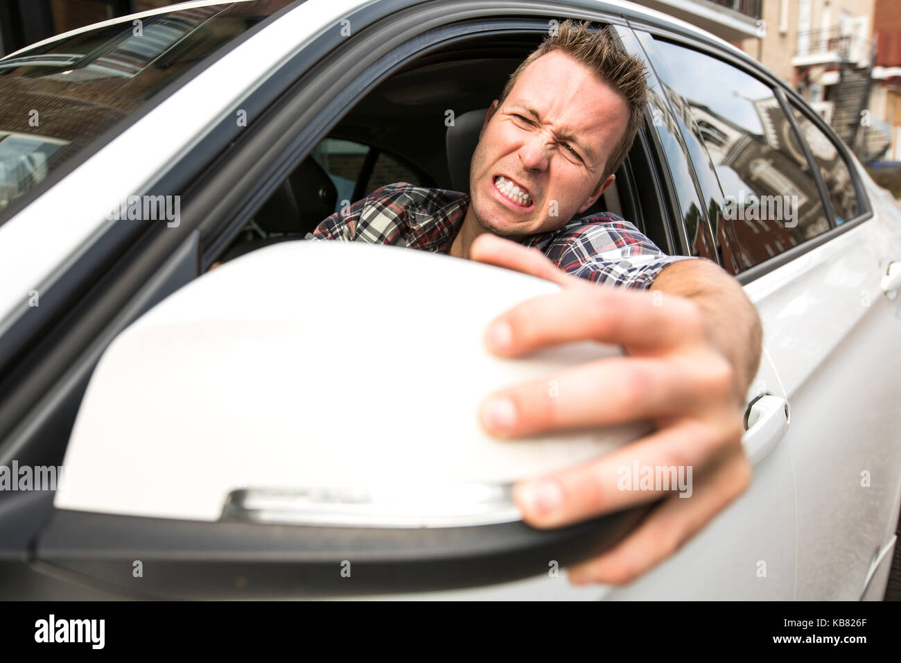 Junger Mann, der ein Auto fährt irritiert. Irritierte Fahrer Stockfoto