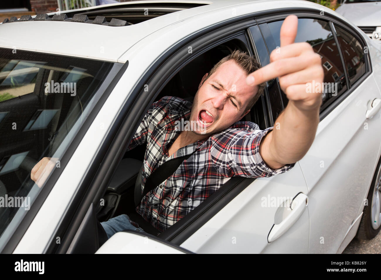 Junger Mann, der ein Auto fährt irritiert. Irritierte Fahrer Stockfoto