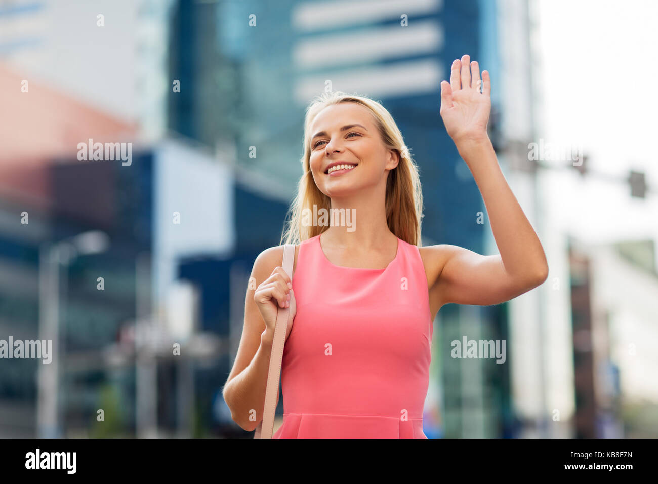 Glückliche junge Frau, die winkende Hand auf Stadt. Stockfoto