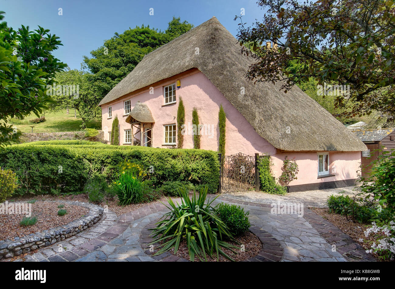 Quintessenz rosa Ferienhaus mit Reetdach in traditionelle Gärten in Cockington Village, Torquay, Devon, Großbritannien Stockfoto