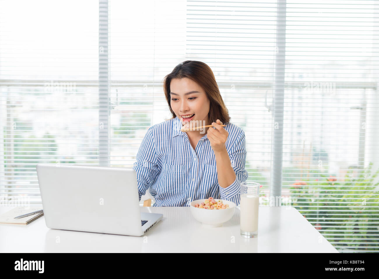 Weibliche Business Executive essen an ihrem Arbeitsplatz Stockfoto