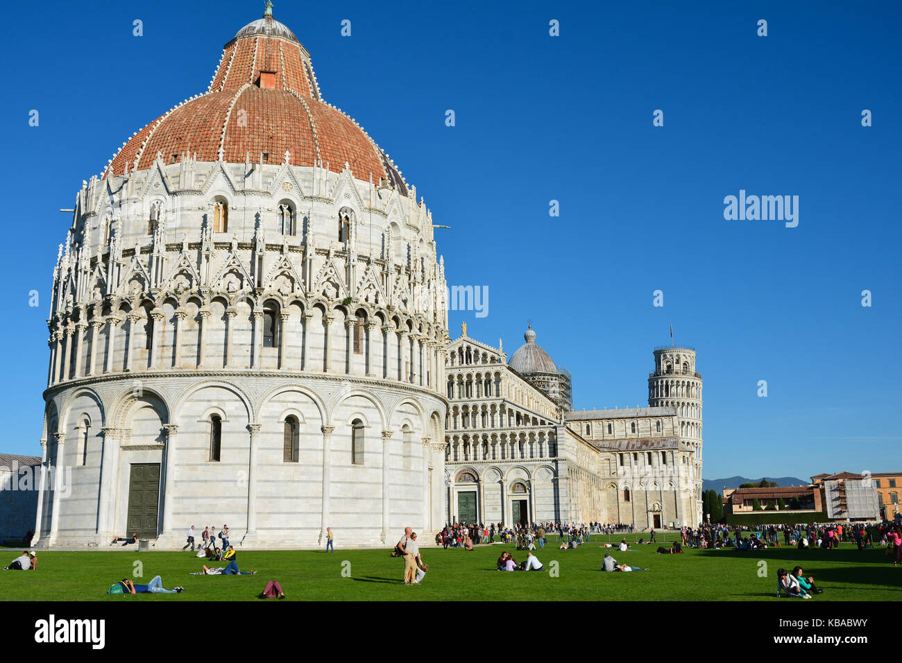 Pisa Baptisterium des Heiligen Johannes im Vordergrund mit dem Schiefen Turm von Pisa im Hintergrund an der Piazza dei Miracoli, Pisa, Italien Stockfoto
