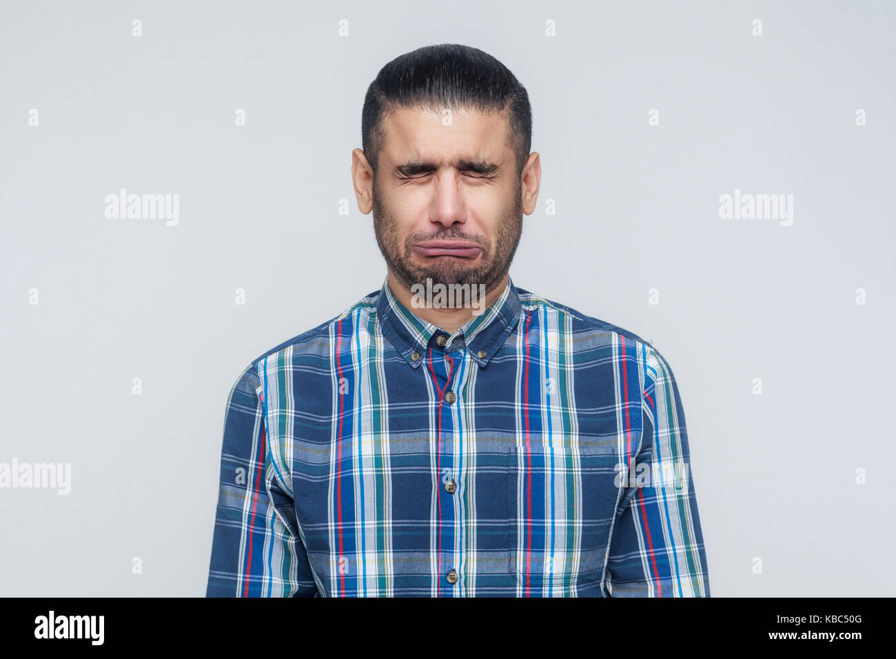 Portrait von unglücklich und deprimiert Mann mit schwarzen Haaren, schäme oder Kranken, halten die Augen geschlossen. Menschliches Gesicht ausdrücken und Emotionen Konzept. Isol Stockfoto