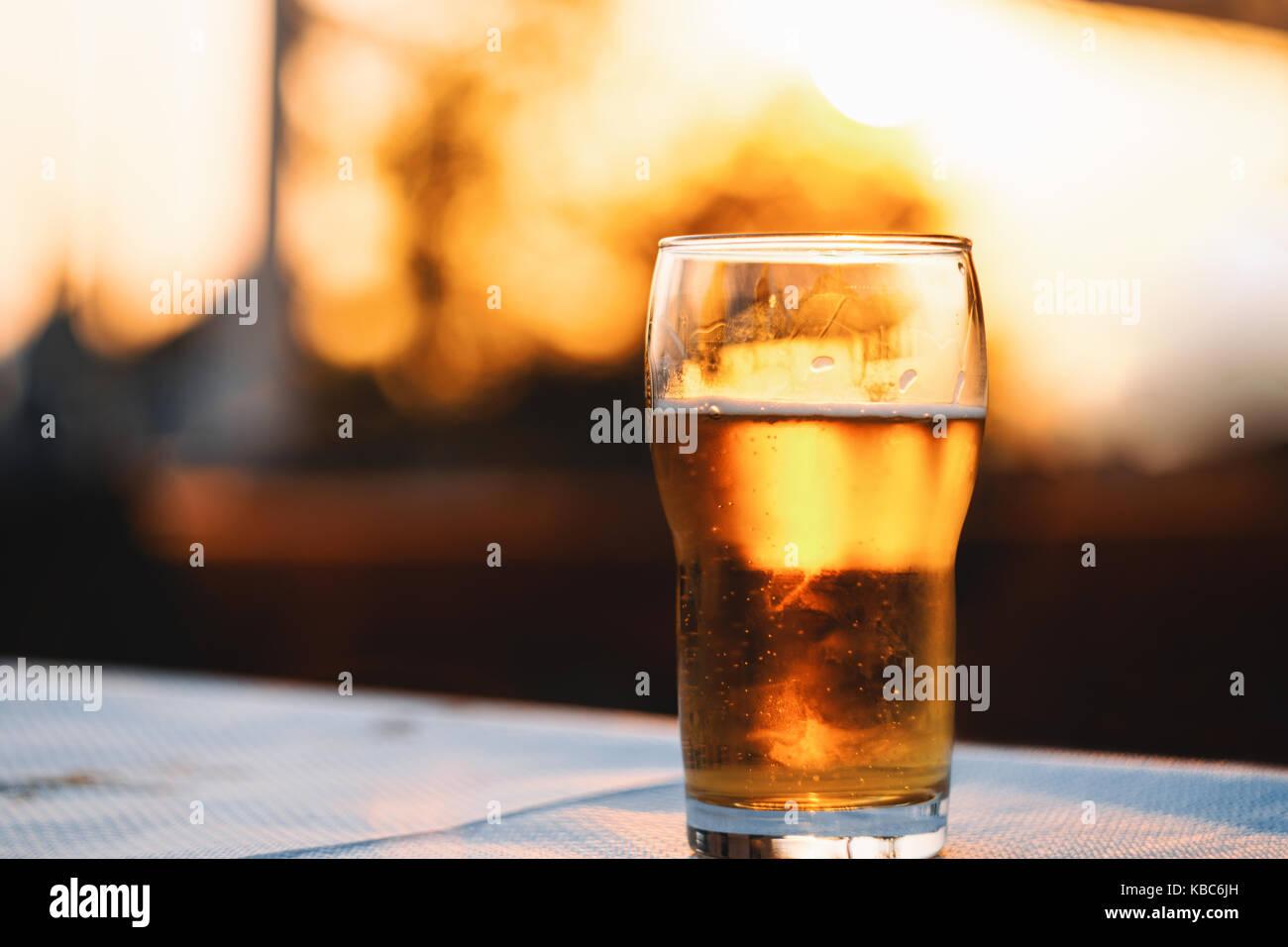 Erfrischende kalte Lagerbier Festlegung auf Tisch gegen Himmel bei Sonnenuntergang Stockfoto