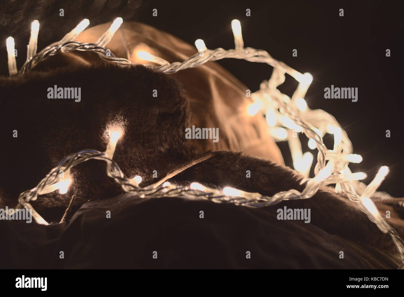 Abstrakte Schoß der alten russischen Ushanka Hut bedeckt In leuchtenden weißen Weihnachten Lichter bei Nacht Stockfoto