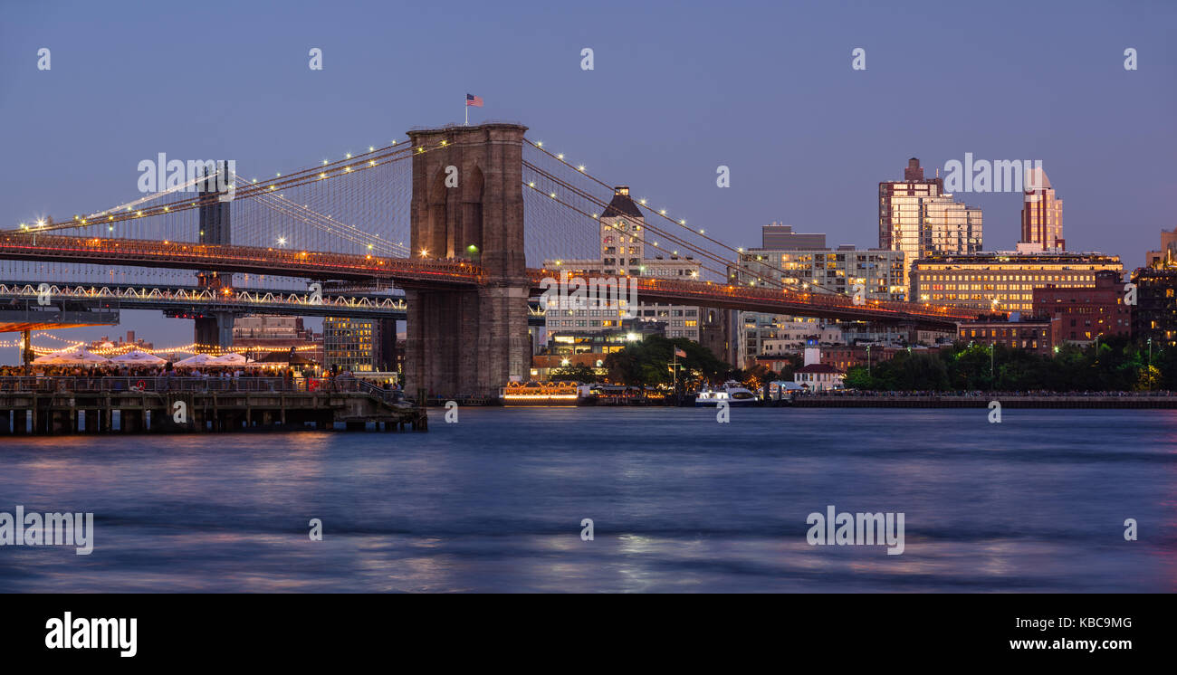 Panoramablick von Brooklyn Riverfront mit der Brooklyn Bridge bei Dämmerung, die Manhattan Bridge und Brooklyn Bridge Park. Brooklyn, New York City Stockfoto