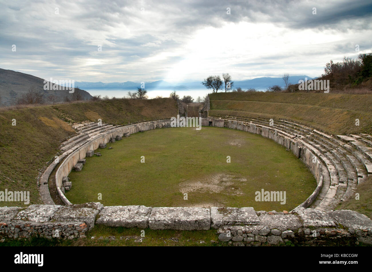 Blickt man auf das antike römische Amphitheater in Alba Fucens, Italien, dating in der ersten Hälfte des ersten Jahrhunderts, mit fucino Plateau im Hintergrund Stockfoto