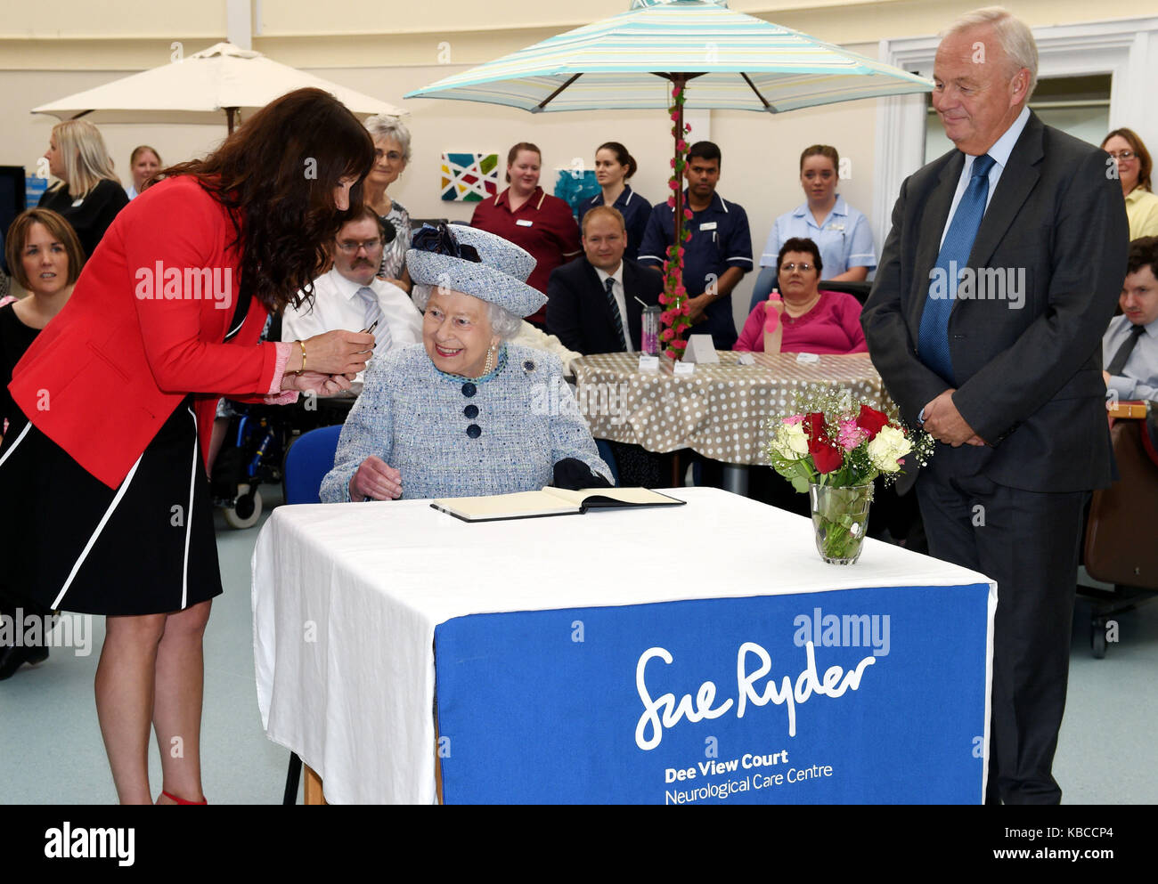 Königin Elizabeth II. unterzeichnet die Besucher buchen Sie bei einem Besuch in Sue Ryder in Kincorth, Aberdeen. Stockfoto