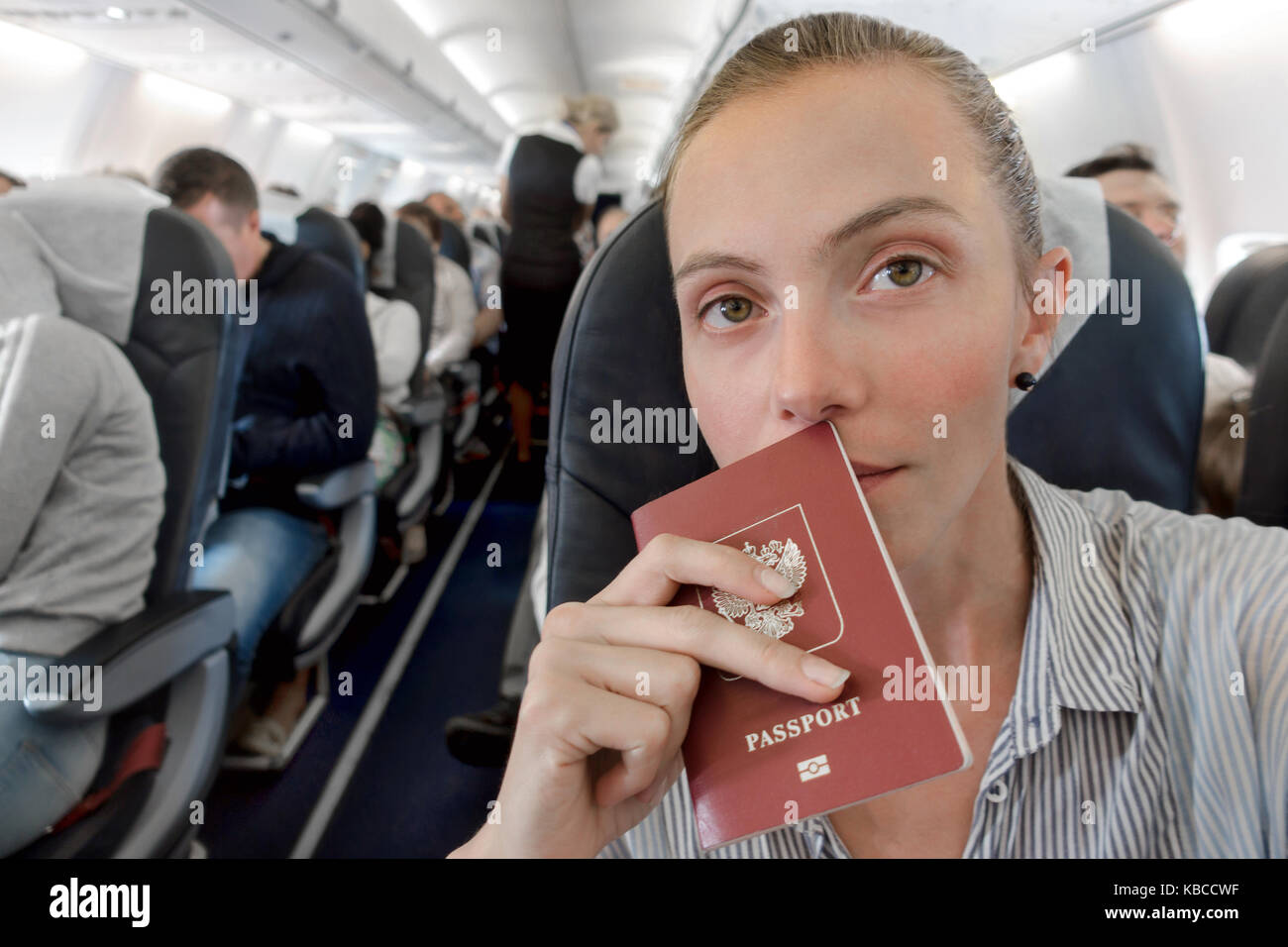 Frau mit einem Pass Sitzen im Flugzeug Interieur Stockfoto