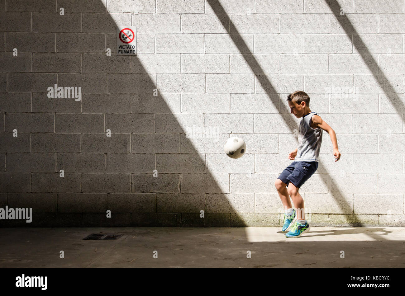Straße Fußball. Junger Mann Fußball-Spieler. Einsame Training in der Garage. Schwarz-weiss Bild. Stockfoto