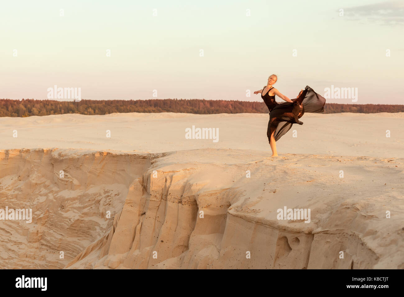 Tänzerin führt auf einer Düne, führt Sie die Leistung. Stockfoto