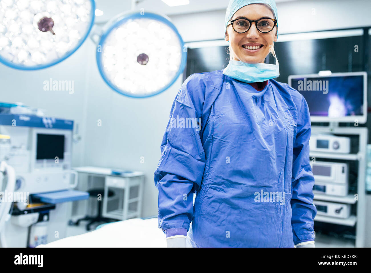 Portrait von lächelnd weibliche Chirurg in chirurgischen einheitliche im Operationssaal. Junge Frau Doktor im Krankenhaus operation Theater. Stockfoto