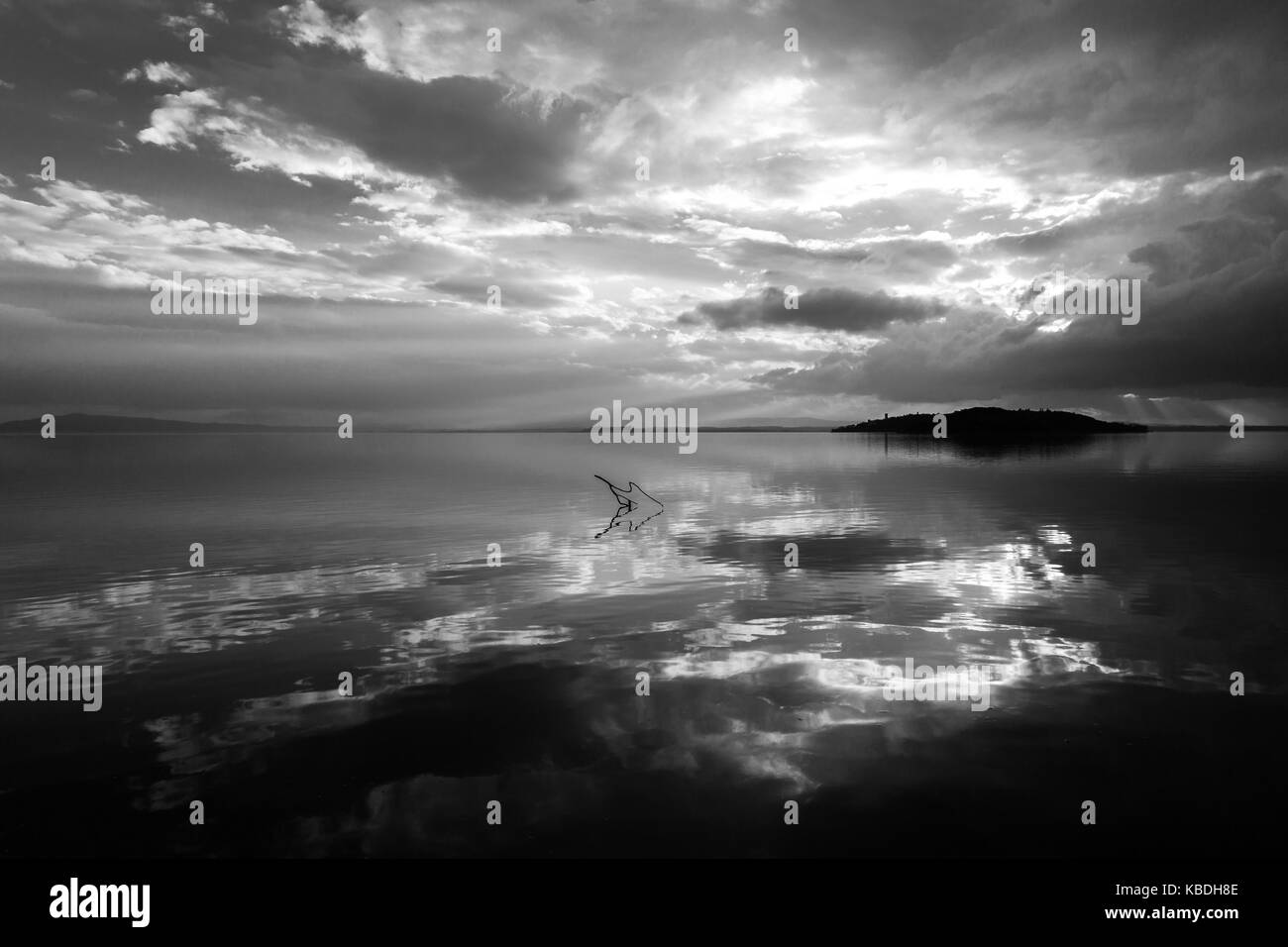 Perfekt symmetrische Reflexionen einer Insel und Wolken an einem See. Stockfoto