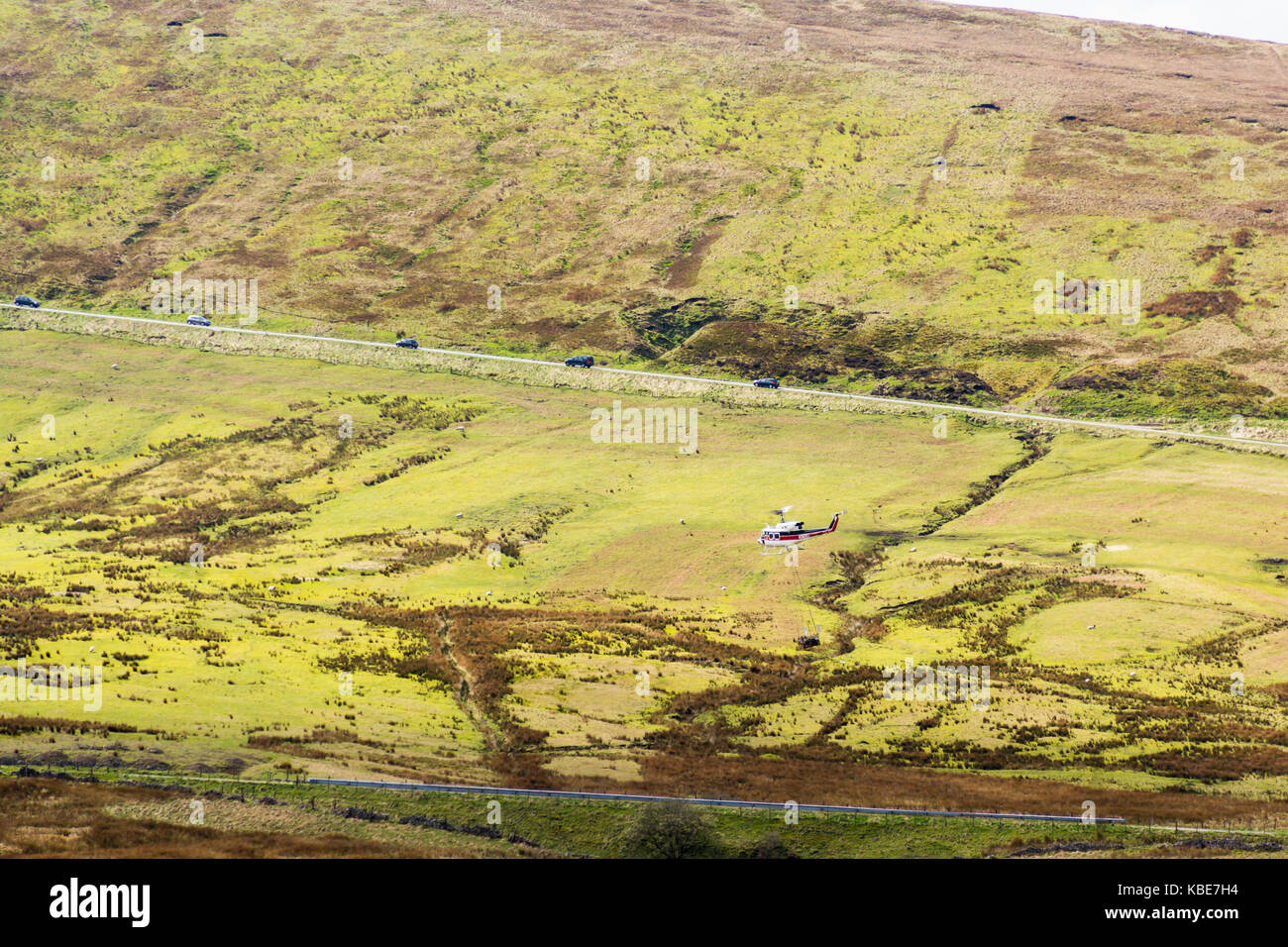Buxton, Großbritannien. 2. April 2017. Bell 212 Hubschrauber Registrierung N 362 EH in Hebezeuge Baumaterial in einem underslung Hopper zu einem inaccessibl Stockfoto