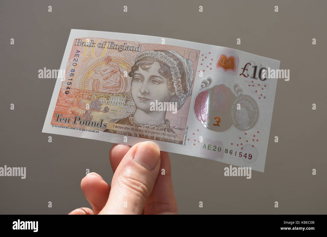 Nahaufnahme der Seniorin, die die neue Note "Sterling Ten Pound" aus Polymer mit Jane Austen hält. Stockfoto