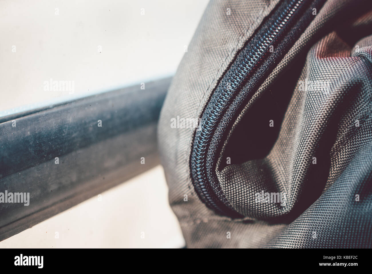 Nahaufnahme der Oliv Rucksack mit schwarzem Reißverschluss ruht auf dem Zug Fenster während der Fahrt Stockfoto