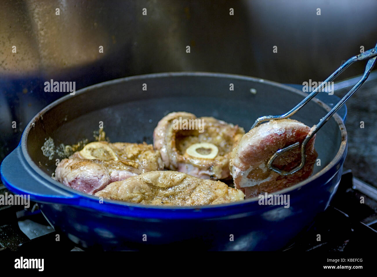 Kochen Kalbfleisch Schäfte mit Mehl in der Pfanne für die Zubereitung von Osso buco Stockfoto