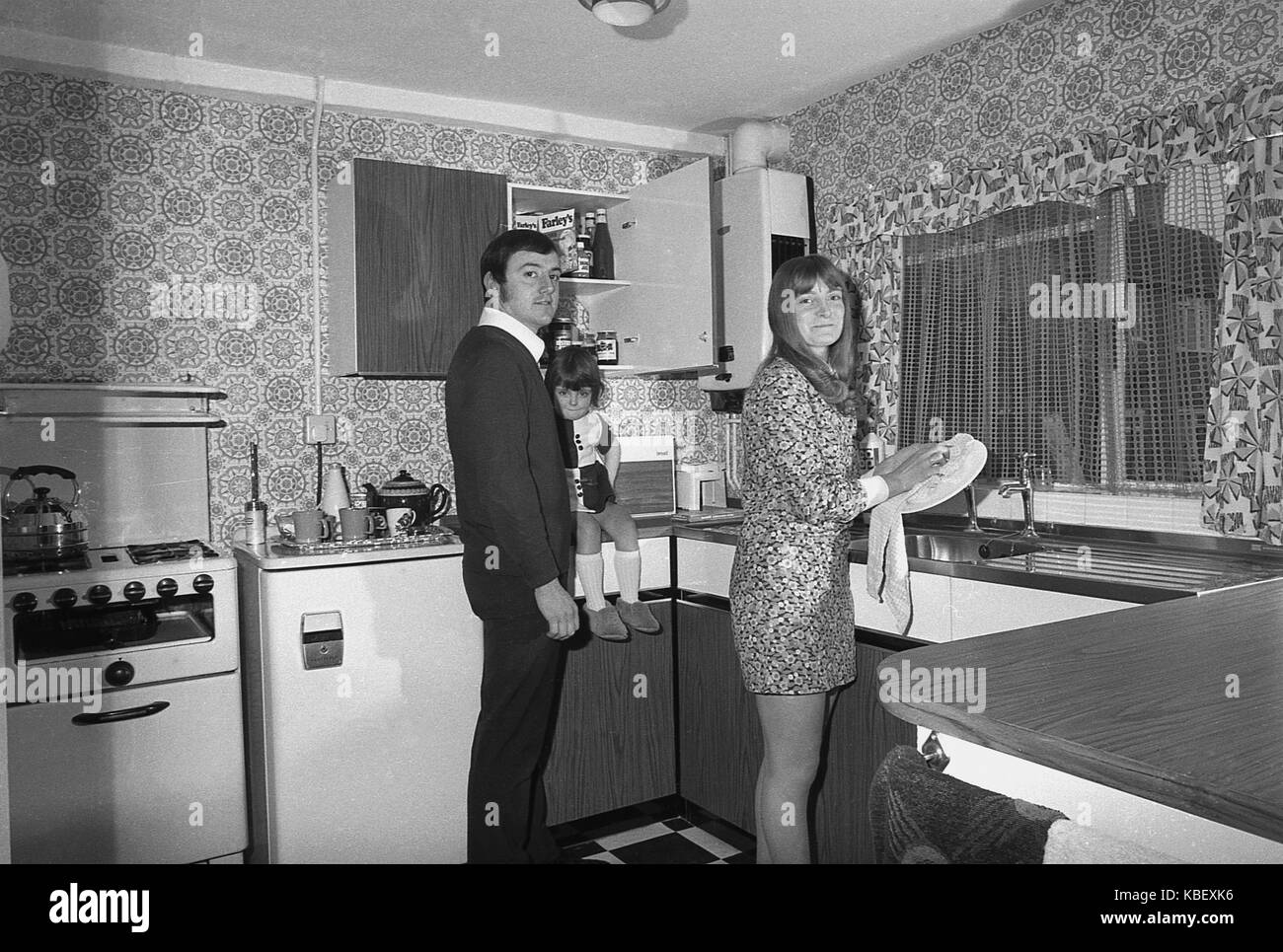 1972, historische, Mann und Frau mit Kind in der Küche ihrer vor kurzem renoviert Rat flach, Baildon Street, Deptford, London, SE8, England, UK. Stockfoto