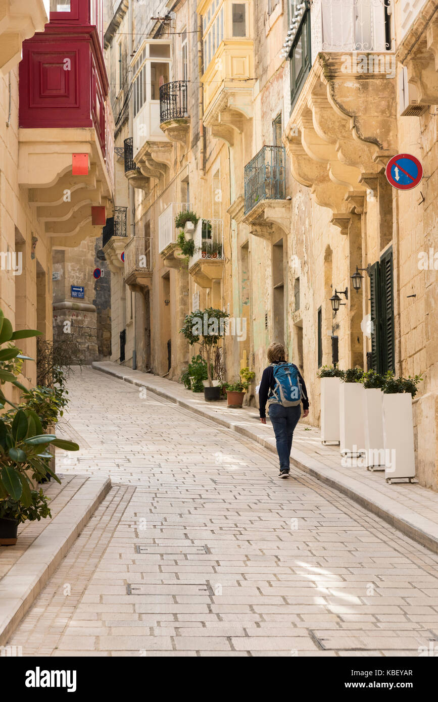 Eine schmale Straße in der mittelalterlichen Stadt von Vittoriosa Malta mit alten honigfarbenen Steingebäude und gepflasterten Pfad Stockfoto