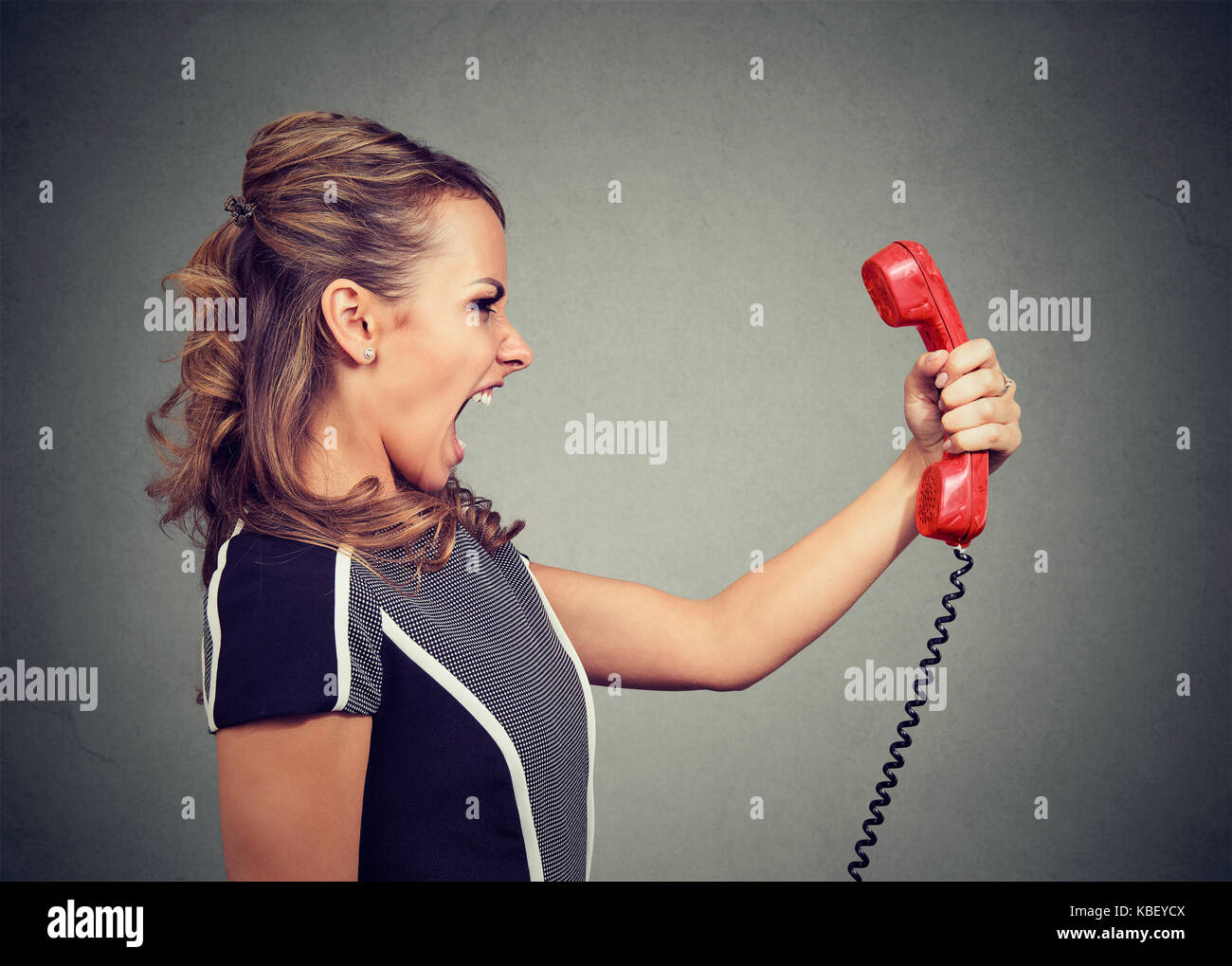 Portrait einer jungen Frau am Telefon wütend Schreien Stockfoto