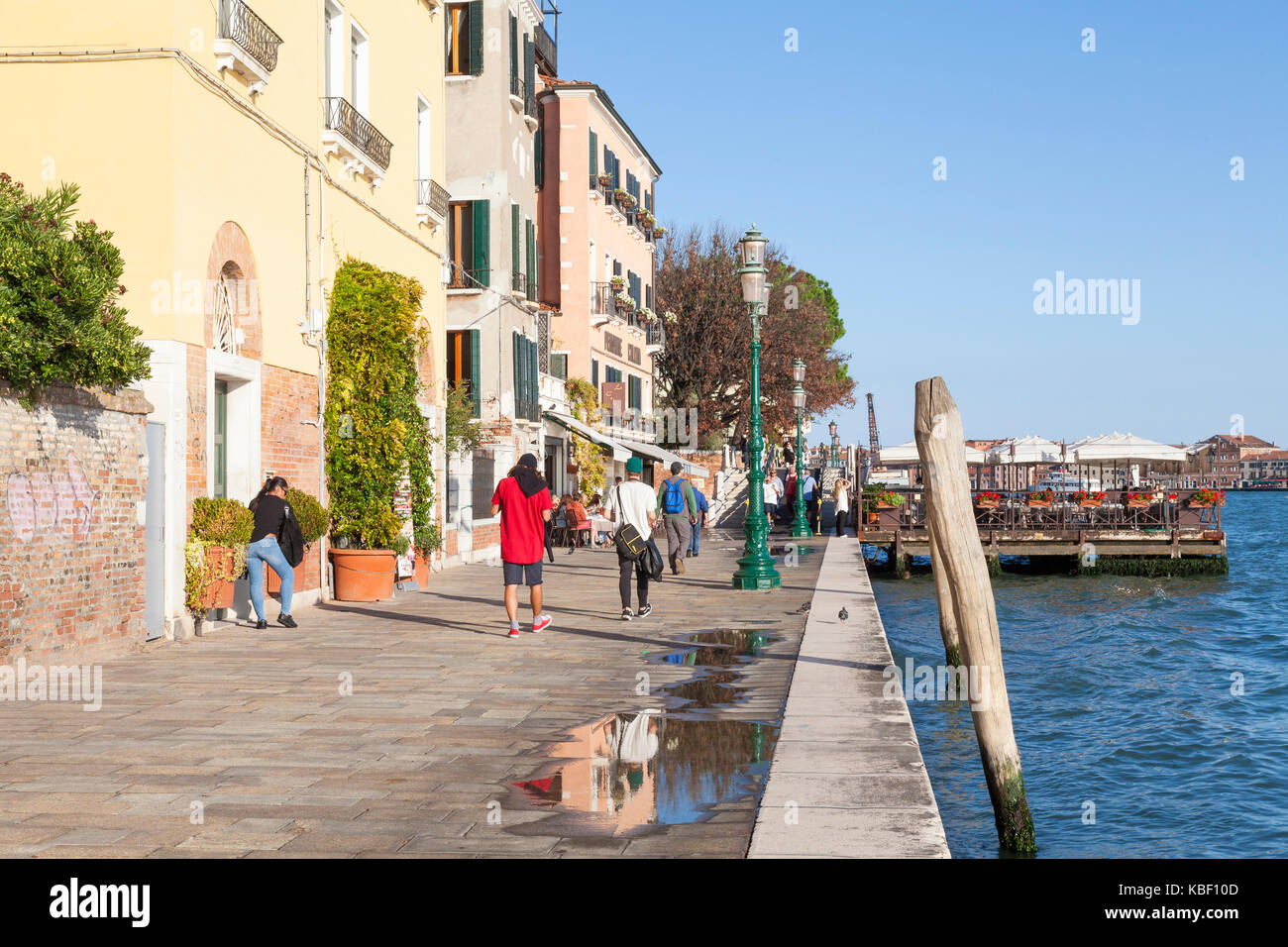 Zattere, Dorsoduro Venedig, Venetien, Italien im späten Abendlicht mit Touristen zu Fuß und das Essen an ein Open air Restaurant auf einem Ponton Stockfoto
