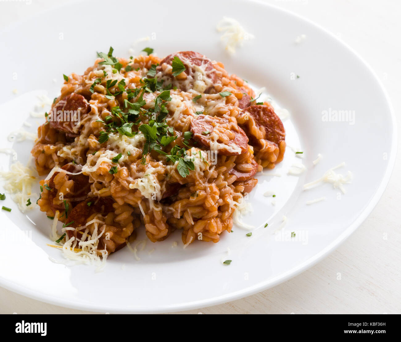 Chorizo Risotto mit Tomaten und Rotwein auf dem weißen Teller Stockfoto