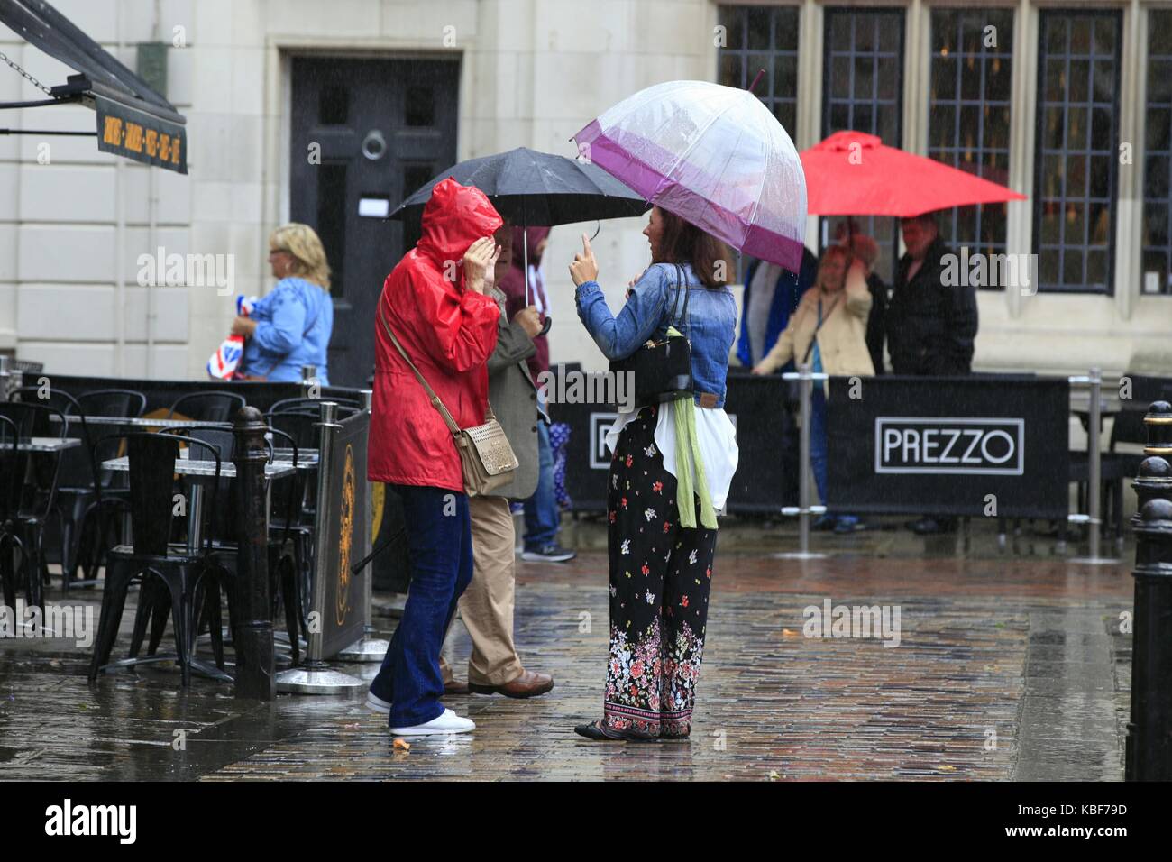 Canterbury, Kent, Großbritannien. 29. September 2017. Eine Gruppe von Damen Menschen mit Sonnenschirmen sprechen im strömenden Regen in der High Street. Foto Paul Lawrenson/Alamy leben Nachrichten Stockfoto