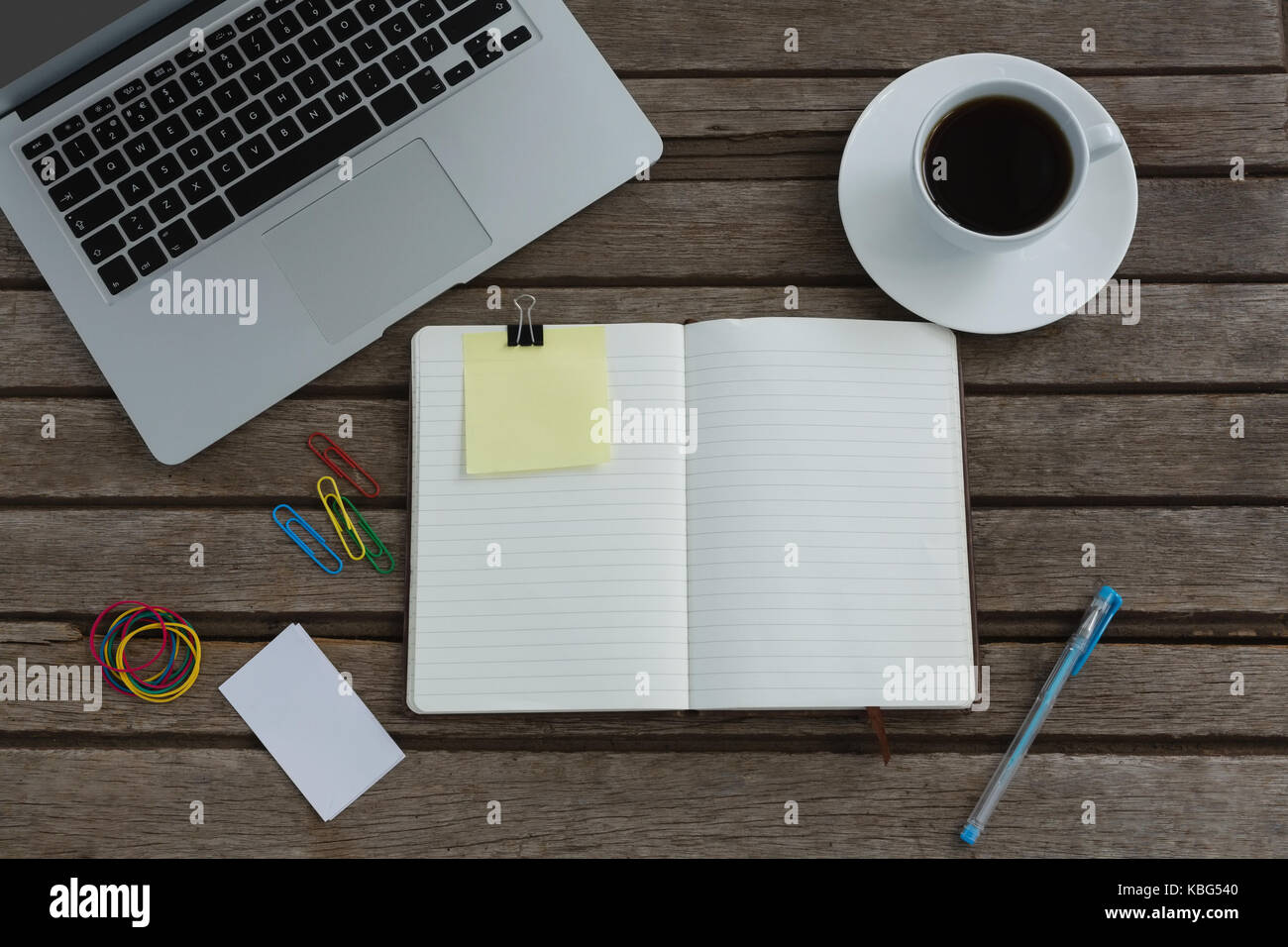 Overhead von schwarzen Kaffee, Laptop, Organizer und Schreibwaren auf Holzbrett Stockfoto